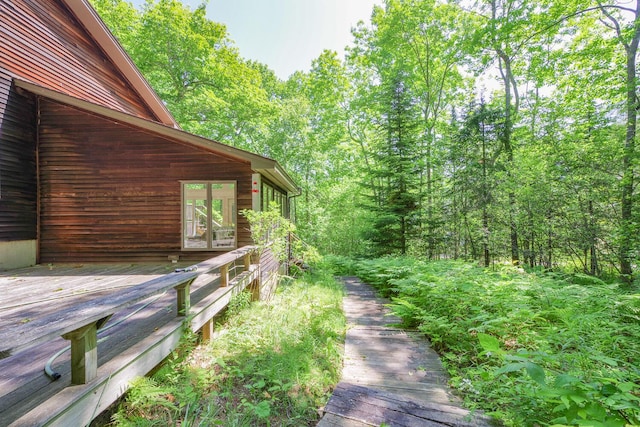 619 Shore Rd, Northport, ME 04849 - view of yard featuring a wooden deck and a forest view