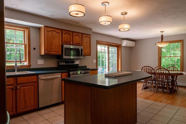 3350 Middle Rd, Sidney, ME 04330 - kitchen featuring stainless steel appliances, a wall mounted AC, dark countertops, light tile patterned floors, and brown cabinetry
