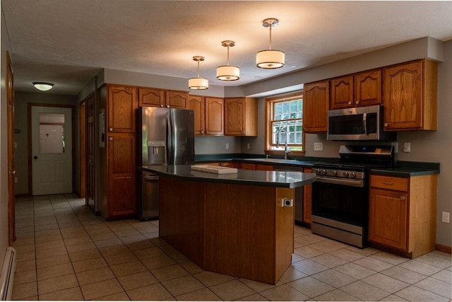 3350 Middle Rd, Sidney, ME 04330 - kitchen with stainless steel appliances, light tile patterned flooring, dark countertops, a center island, and brown cabinetry