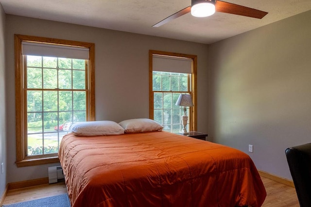 3350 Middle Rd, Sidney, ME 04330 - bedroom featuring light wood finished floors, multiple windows, and a baseboard heating unit