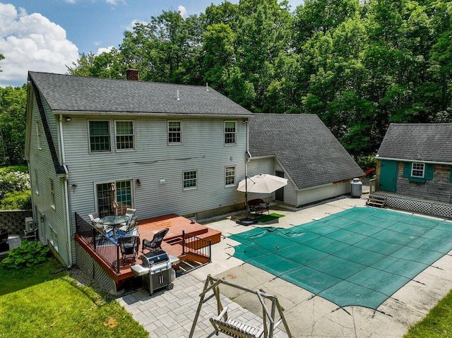 3350 Middle Rd, Sidney, ME 04330 - back of property featuring a deck, a chimney, a patio, and a covered pool