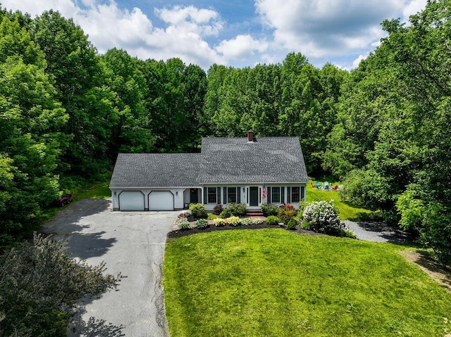 3350 Middle Rd, Sidney, ME 04330 - view of front of property with asphalt driveway, an attached garage, a chimney, a front lawn, and a wooded view