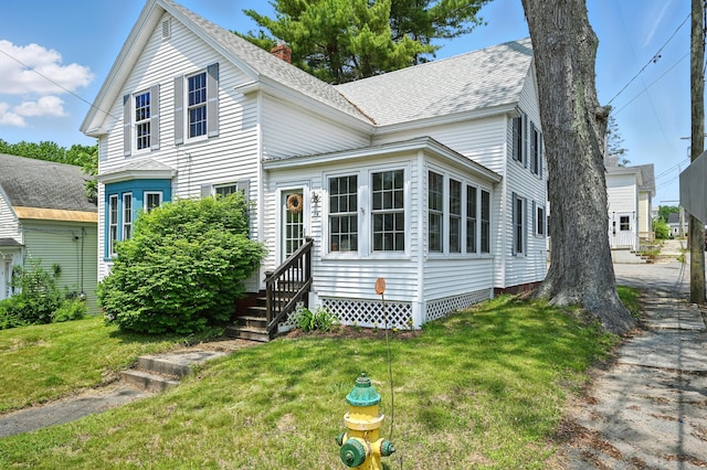 14 Maple St, Lisbon, ME 04252 - traditional home with entry steps, a front yard, roof with shingles, and a chimney