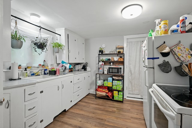 14 Maple St, Lisbon, ME 04252 - kitchen with electric range oven, white cabinetry, light wood finished floors, and light countertops