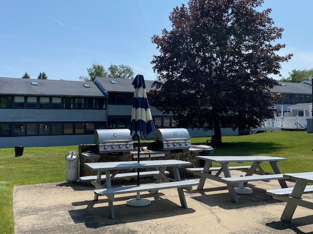 1072 Post Rd Unit 102, Wells, ME 04090 - view of home's community with a lawn, outdoor dining area, and a patio area