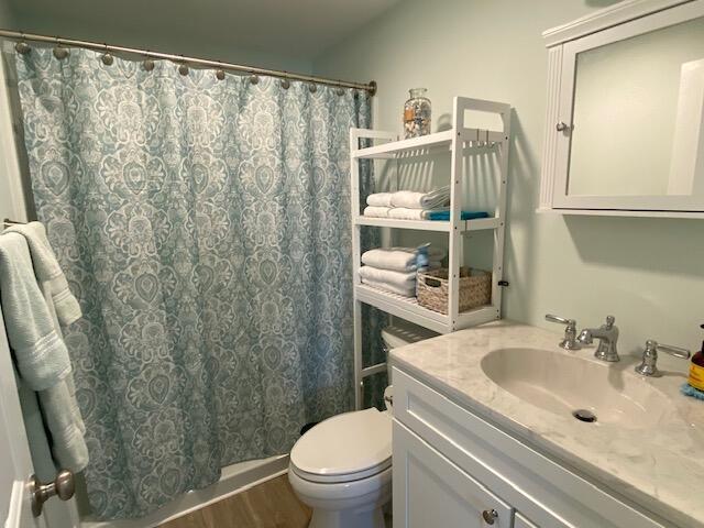 1072 Post Rd Unit 102, Wells, ME 04090 - full bath with vanity, a shower with shower curtain, and wood finished floors