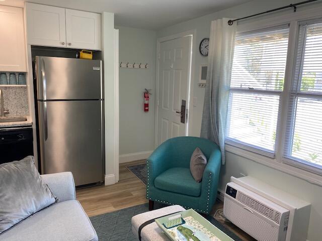 1072 Post Rd Unit 102, Wells, ME 04090 - living area featuring plenty of natural light, light wood-style flooring, and a wall unit AC
