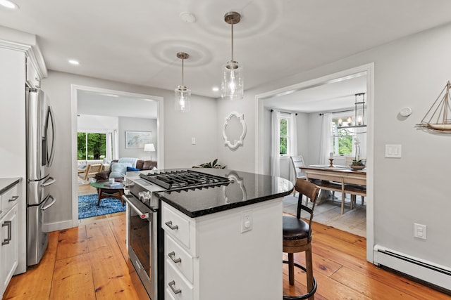 526 E Main St, Yarmouth, ME 04096 - kitchen with appliances with stainless steel finishes, baseboard heating, a center island, a breakfast bar area, and light wood finished floors