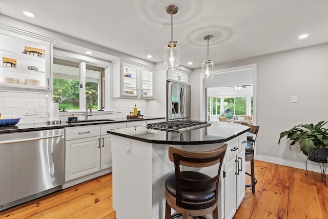 526 E Main St, Yarmouth, ME 04096 - kitchen featuring stainless steel appliances, a breakfast bar area, white cabinetry, dark countertops, and recessed lighting