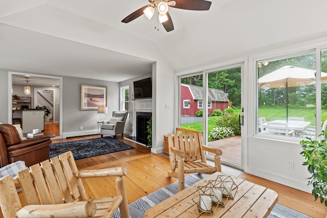 526 E Main St, Yarmouth, ME 04096 - living room featuring baseboard heating, light wood-style floors, a fireplace, ceiling fan, and vaulted ceiling