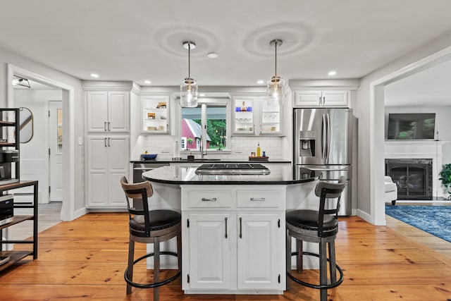 526 E Main St, Yarmouth, ME 04096 - kitchen featuring stainless steel appliances, a breakfast bar, light wood-style floors, tasteful backsplash, and white cabinetry