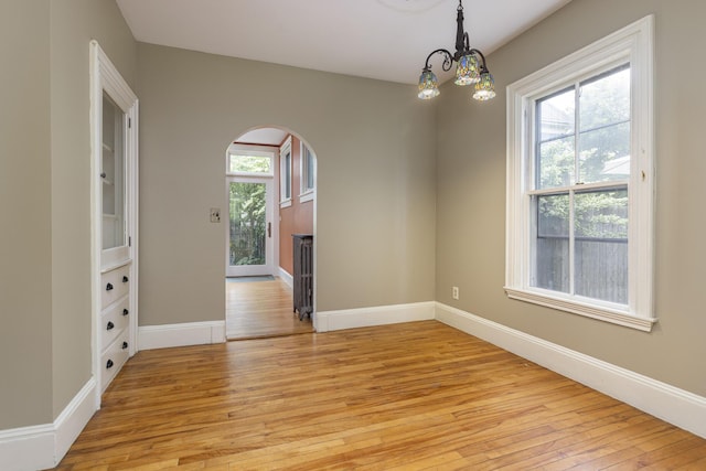 80 Melbourne St, Portland, ME 04101 - empty room featuring light wood-style flooring, a chandelier, and arched walkways