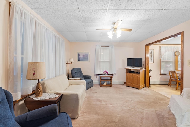 33 Maple St, Limerick, ME 04048 - living area featuring a drop ceiling, a ceiling fan, a baseboard radiator, and light colored carpet