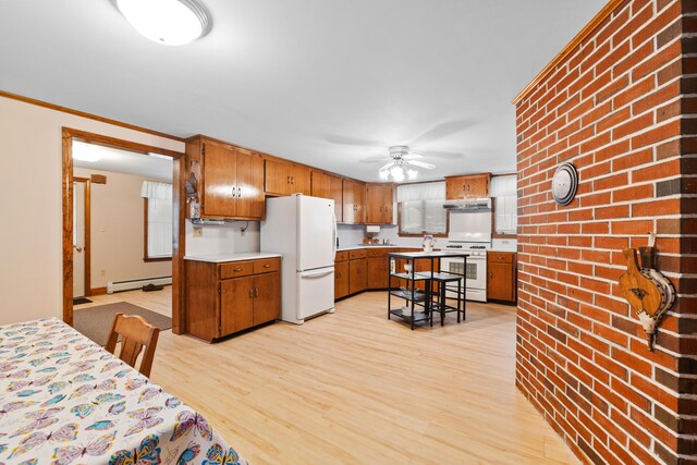 33 Maple St, Limerick, ME 04048 - kitchen featuring white appliances, baseboard heating, light wood-style flooring, brown cabinets, and under cabinet range hood