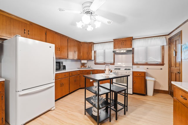 33 Maple St, Limerick, ME 04048 - kitchen with white appliances, under cabinet range hood, brown cabinets, and ceiling fan