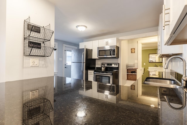 272 Center St, Bangor, ME 04401 - kitchen with appliances with stainless steel finishes, white cabinets, dark stone counters, a peninsula, and under cabinet range hood