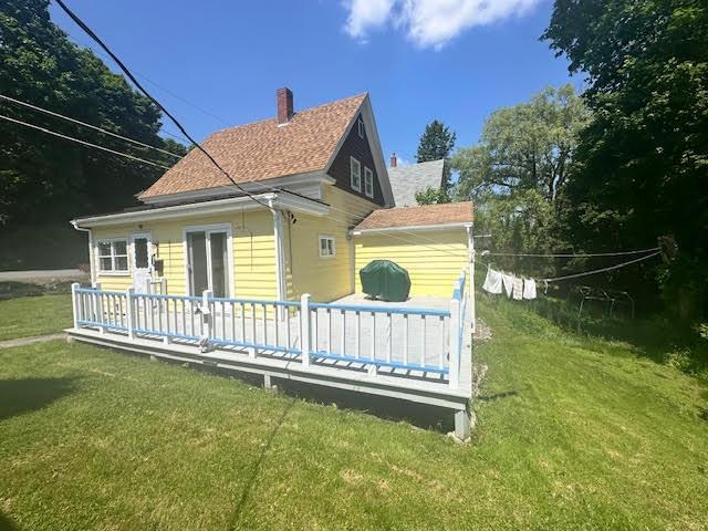 28 Charles St, Belfast, ME 04915 - rear view of house featuring a wooden deck, a lawn, a chimney, and a shingled roof