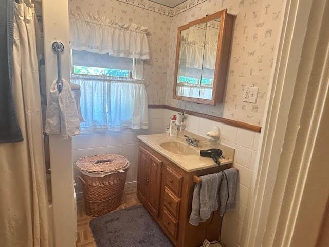 28 Charles St, Belfast, ME 04915 - bathroom with wallpapered walls, wainscoting, and vanity