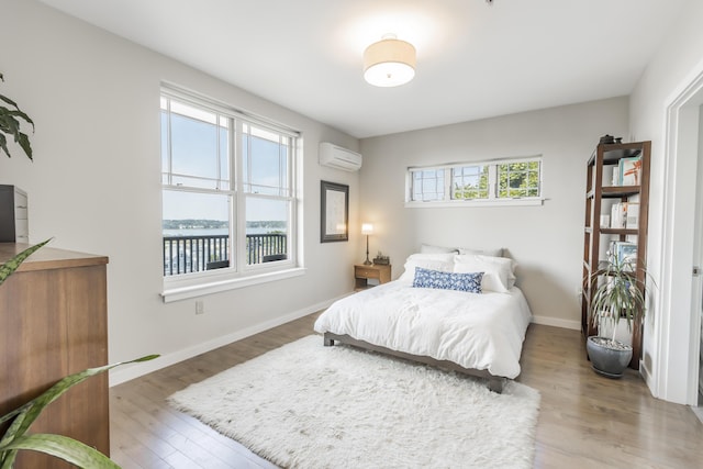 156 Sheridan St Unit 2A, Portland, ME 04101 - bedroom featuring an AC wall unit, wood finished floors, and a water view