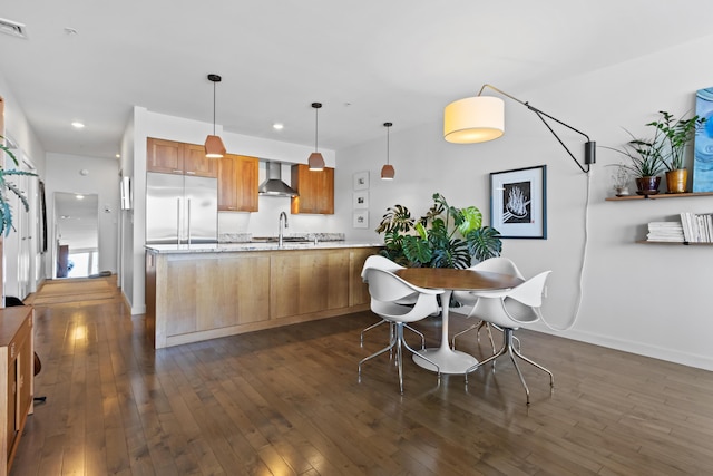156 Sheridan St Unit 2A, Portland, ME 04101 - kitchen featuring built in refrigerator, wall chimney exhaust hood, dark wood-style flooring, a peninsula, and decorative light fixtures