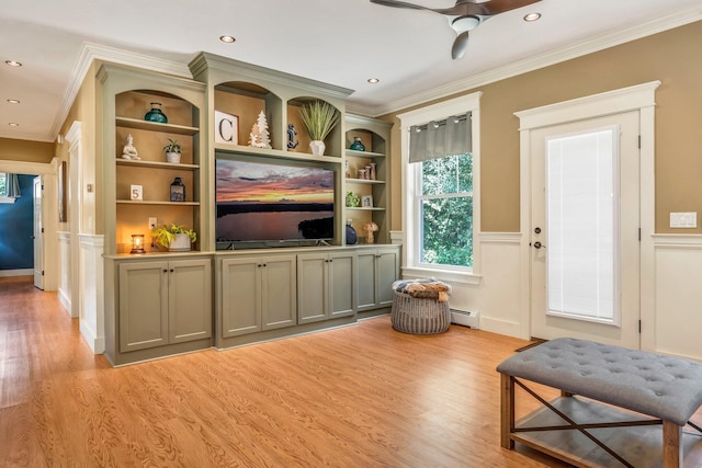 187 Hickory Dr, Auburn, ME 04210 - living room featuring baseboard heating, crown molding, light wood-style flooring, wainscoting, and a ceiling fan