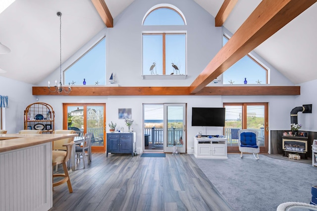 204 Nubble Rd, York, ME 03909 - living room with high vaulted ceiling, beam ceiling, wood finished floors, healthy amount of natural light, and a wood stove