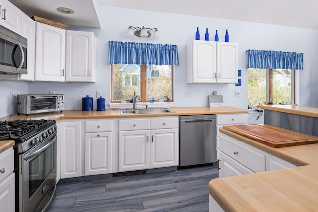 204 Nubble Rd, York, ME 03909 - kitchen with stainless steel appliances, white cabinets, and dark wood-style flooring
