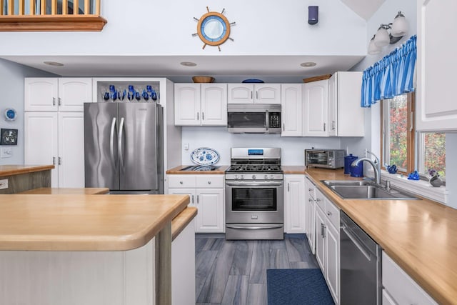 204 Nubble Rd, York, ME 03909 - kitchen with stainless steel appliances, white cabinets, dark wood finished floors, lofted ceiling, and wooden counters