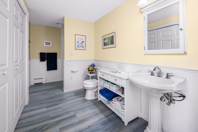 204 Nubble Rd, York, ME 03909 - bathroom with wainscoting, baseboard heating, and wood finished floors