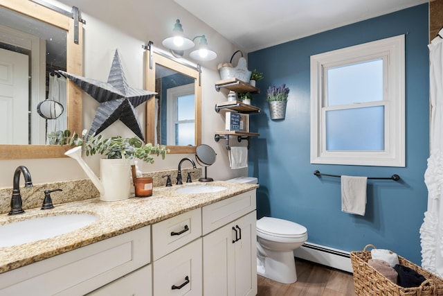 15 Lindale Ave, Biddeford, ME 04005 - full bath with a baseboard radiator, wood finished floors, double vanity, and healthy amount of natural light