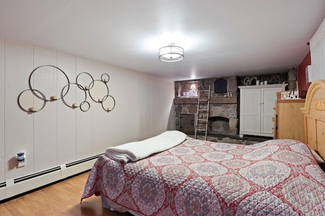 15 Lindale Ave, Biddeford, ME 04005 - bedroom featuring a baseboard heating unit, wood finished floors, and a stone fireplace