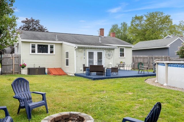 15 Lindale Ave, Biddeford, ME 04005 - rear view of house with a chimney, a fenced backyard, a patio area, french doors, and an outdoor living space with a fire pit