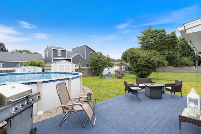 15 Lindale Ave, Biddeford, ME 04005 - fenced backyard with a fire pit, a storage unit, a grill, a patio area, and a residential view
