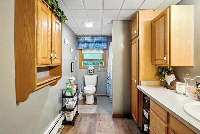 189 Old Chadbourne Rd, Lewiston, ME 04240 - full bathroom featuring wood finished floors, a paneled ceiling, vanity, and baseboard heating