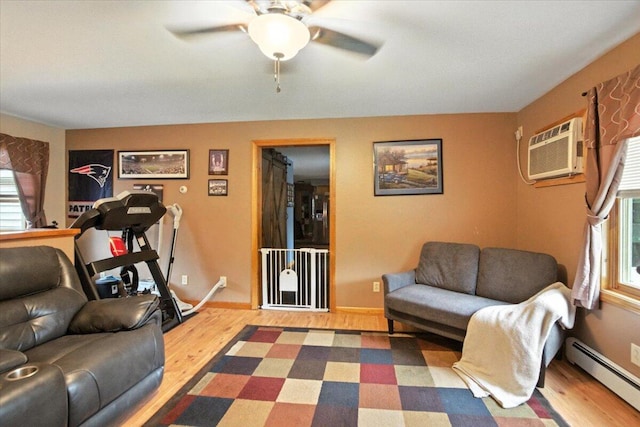 189 Old Chadbourne Rd, Lewiston, ME 04240 - living room featuring a baseboard heating unit, a wall unit AC, wood finished floors, and ceiling fan