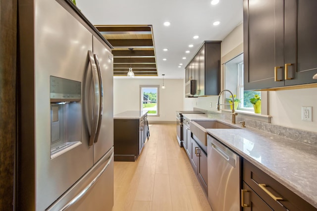 1719 Dixmont Rd, Etna, ME 04434 - kitchen with stainless steel appliances, recessed lighting, light wood-style floors, light stone counters, and dark brown cabinets