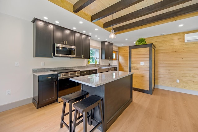 1719 Dixmont Rd, Etna, ME 04434 - kitchen featuring stainless steel appliances, wood walls, light wood-style flooring, a wood ceiling with exposed beams, and a kitchen island