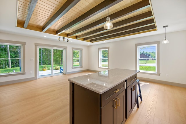 1719 Dixmont Rd, Etna, ME 04434 - kitchen with open floor plan, light wood finished floors, light stone countertops, decorative light fixtures, and a wooden ceiling with exposed beams
