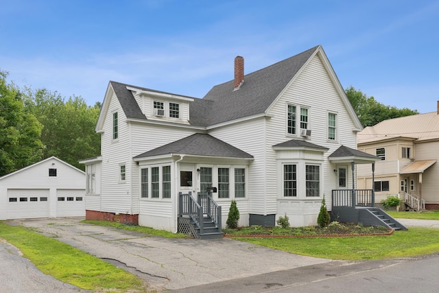 25 Searles St, Livermore Falls, ME 04254 - view of front facade featuring an outbuilding, a detached garage, a shingled roof, and a chimney