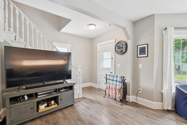 25 Searles St, Livermore Falls, ME 04254 - living area with light wood finished floors, arched walkways, and stairway