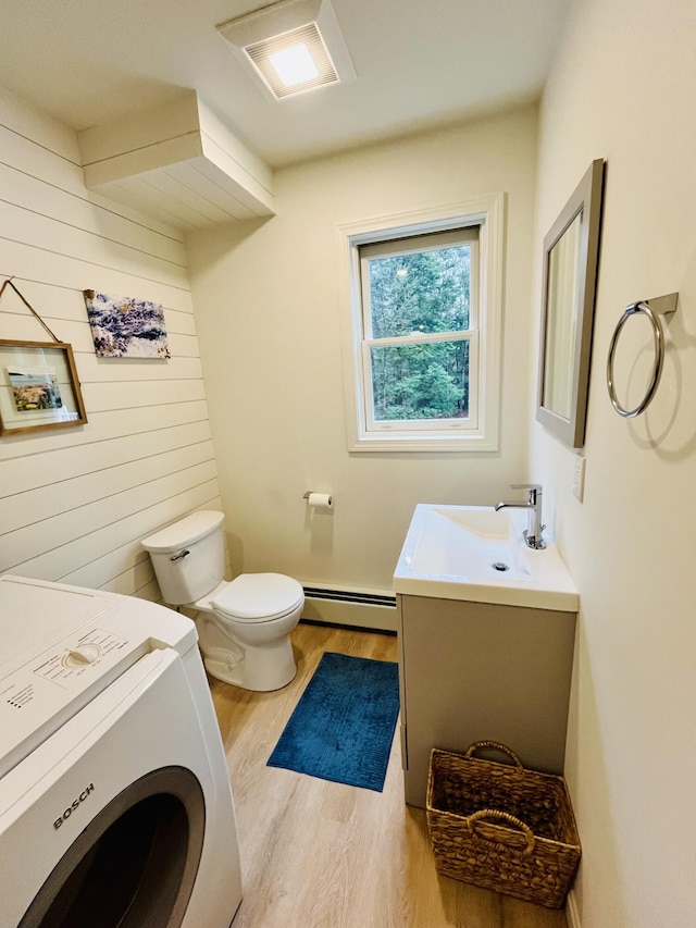 66 Stoney Acres Rd, Pittston, ME 04345 - bathroom with a baseboard radiator, washer / dryer, wood finished floors, vanity, and wood walls
