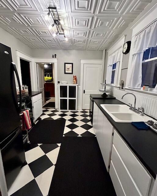 28 Holly St, Auburn, ME 04210 - kitchen featuring freestanding refrigerator, dark floors, an ornate ceiling, white cabinets, and dark countertops