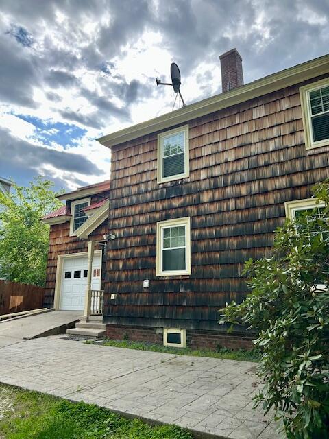 28 Holly St, Auburn, ME 04210 - view of home's exterior featuring a garage and a chimney