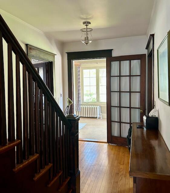 28 Holly St, Auburn, ME 04210 - foyer with radiator heating unit, stairway, and hardwood / wood-style flooring