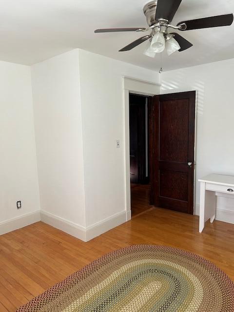 28 Holly St, Auburn, ME 04210 - empty room with light wood-style floors and a ceiling fan