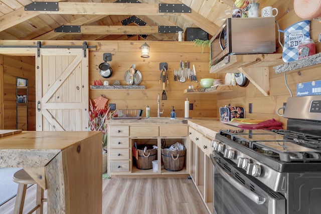16 Keystone Spring Rd, Poland, ME 04274 - kitchen with appliances with stainless steel finishes, wood walls, light wood finished floors, wood ceiling, and a barn door