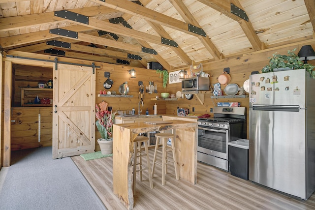 16 Keystone Spring Rd, Poland, ME 04274 - kitchen featuring stainless steel appliances, wood walls, butcher block counters, wooden ceiling, and a barn door