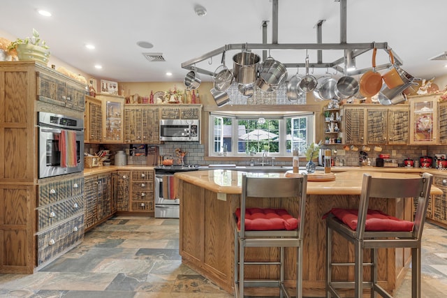 16 Keystone Spring Rd, Poland, ME 04274 - kitchen with stainless steel appliances, light countertops, light stone finish floors, decorative backsplash, and recessed lighting