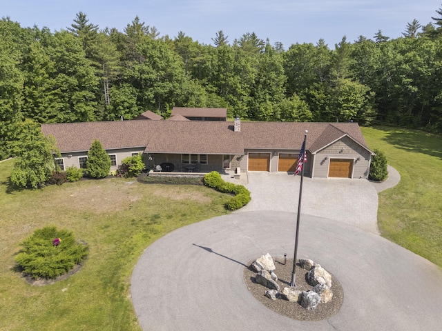 16 Keystone Spring Rd, Poland, ME 04274 - single story home featuring curved driveway, a garage, a front lawn, and a wooded view