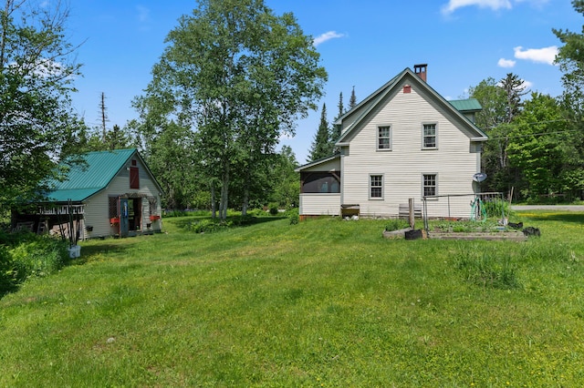 574 Mingo Loop Rd, Rangeley, ME 04970 - view of grassy yard featuring a sunroom and a vegetable garden